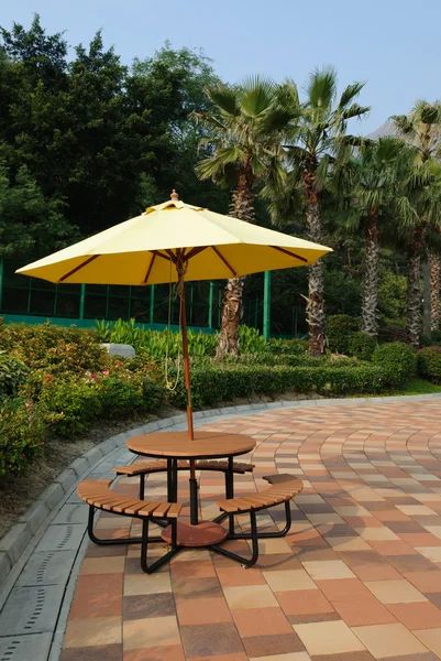 Patio umbrella with blue sky and tree background