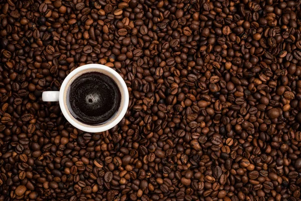 Kopje Vol Zwarte Koffie Een Achtergrond Van Koffiebonen — Stockfoto