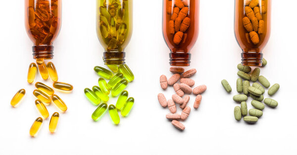 Различные добавки таблетки с бутылками на белом фоне
