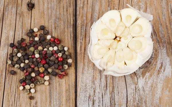 Knoblauch mit Pfeffer auf Holz — Stockfoto