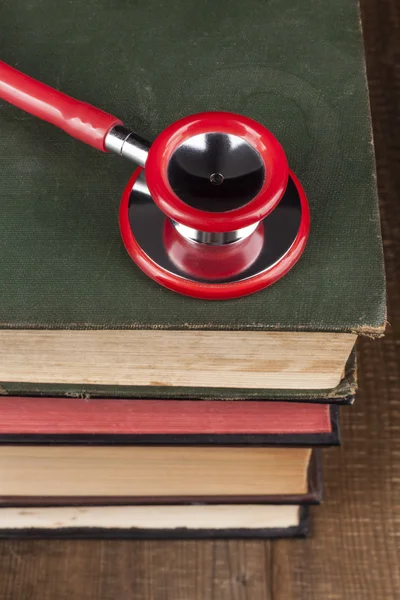 Rotes Stethoskop auf Bücherstapel — Stockfoto