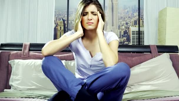 Kvinna sitter i sängen håller huvudet känsla stark migrän 4k — Stockvideo