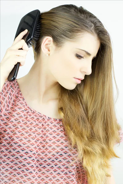 Hermosa joven mujer cepillando pelo largo y rubio — Foto de Stock