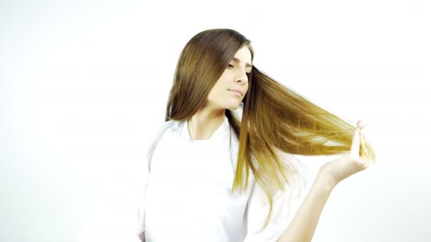 Belle femme touchant de longs cheveux soyeux après la coupe de cheveux et le style isolé 