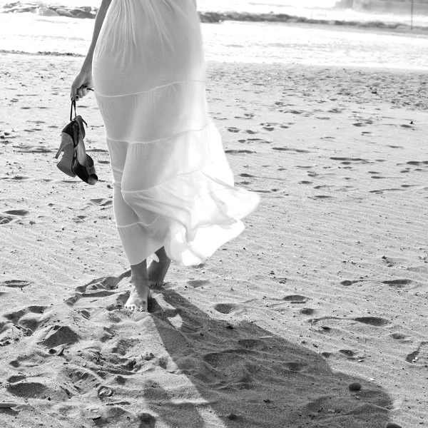 Schwarz-weiß Porträt einer Frau mit Schuhen und Schatten am Strand — Stockfoto