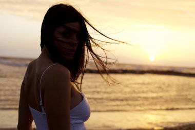 Kadın model okyanus portre üzerinde güzel gün batımı önünde poz