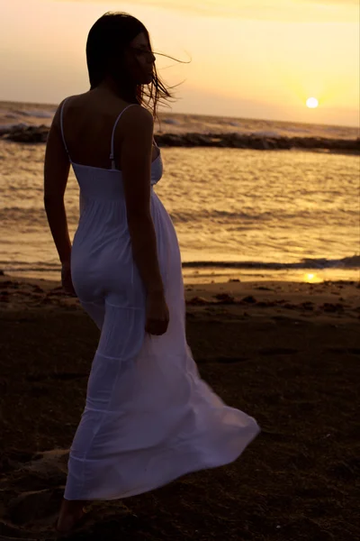 Modelo feminino posando na frente do belo pôr do sol no oceano — Fotografia de Stock