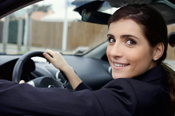 Niedliche Frau lächelt im Auto sitzend — Stockfoto