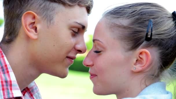 Jovem casal apaixonado beijando no parque close up retrato — Vídeo de Stock