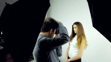 Kulise fotoğraf oturumunda stüdyo ile kadın modeli ve fotoğrafçı