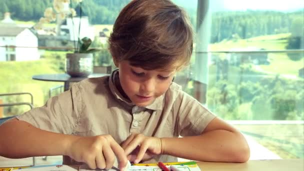 Дитина робить домашнє завдання вдома в горах крупним планом ляльковий постріл — стокове відео