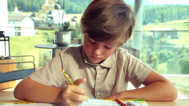 Niño haciendo la tarea en casa en las montañas cansándose primer plano — Vídeo de stock