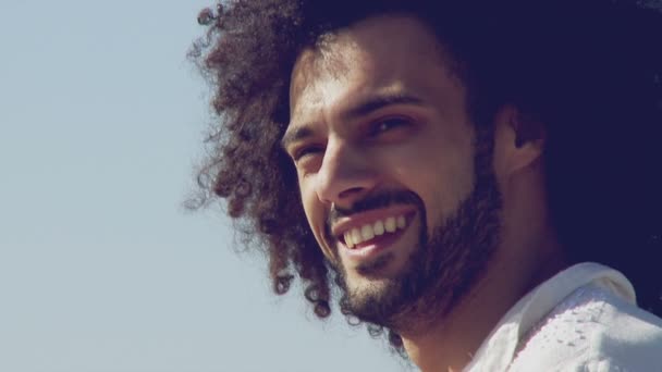 Jóképű férfi modell mosolyogva látszó kamera előtt a sky-lassú mozgás — Stock videók