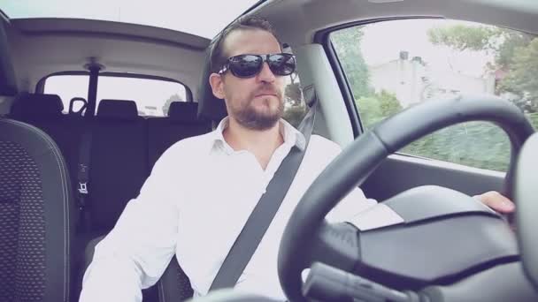 Homme sérieux avec chemise blanche voiture de conduite avec des lunettes de soleil style rétro — Video