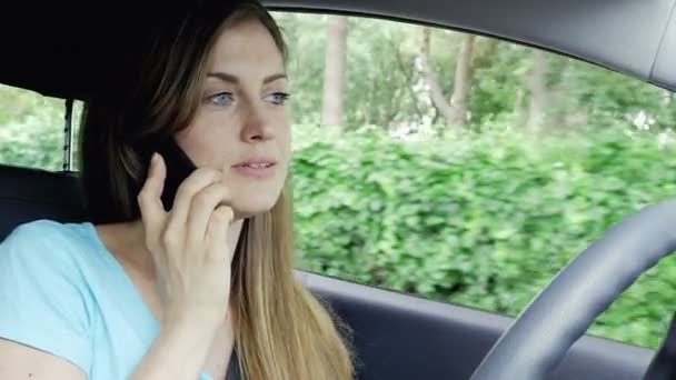 Mujer rubia hablando en serio en el teléfono mientras conduce el primer plano del coche 4K — Vídeos de Stock