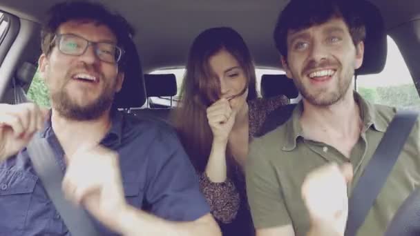 Mulher cantando no carro com dois amigos do sexo masculino indo de férias no verão retro — Vídeo de Stock