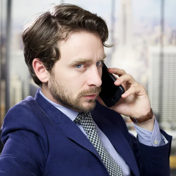 Seriöser Geschäftsmann am Telefon im Büro — Stockfoto