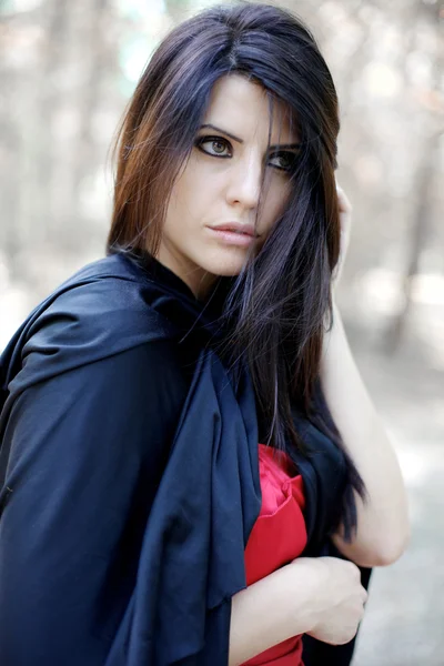 Portrait de belle jeune femme au manteau noir dans les bois magiques — Photo