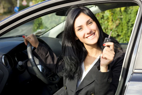 Heureuse femme souriante à l'intérieur de voiture montrant les clés — Photo