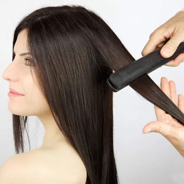 Mulher recebendo cabelo endireitado após guarnição no salão profissional — Fotografia de Stock