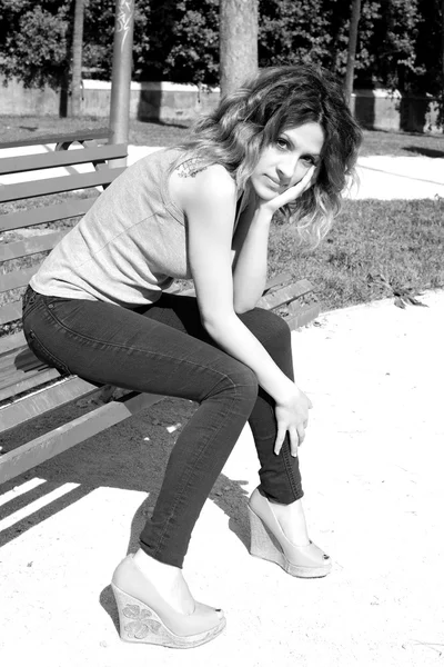 公園のベンチの上に座ってのボーイ フレンドを待っている女 — ストック写真