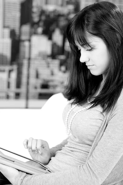 Černobílý portrét ženy čtení tabletu doma — Stock fotografie
