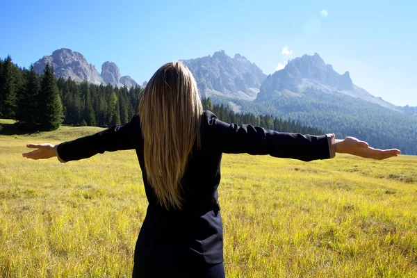 Mujer rubia mirando las montañas feliz — Foto de Stock