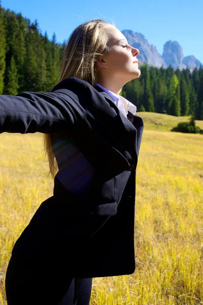 Blonde business woman enjoying air in the mountain — Stock Photo, Image