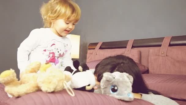 小さな女の子馬乗馬若い母の寝室の再生で幸せ — ストック動画