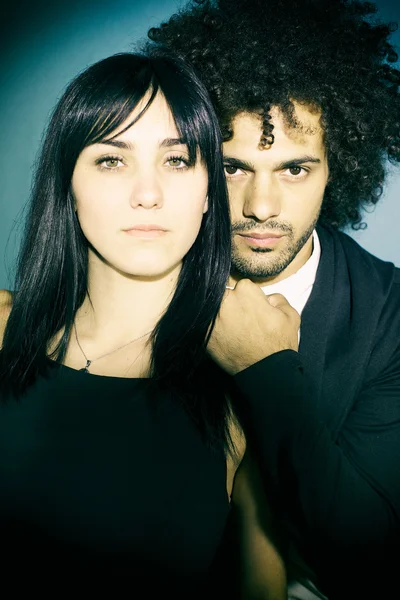 Cool fashionable couple posing in studio looking — Stock Photo, Image