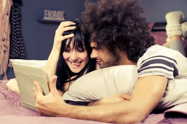 Casal a tomar selfie com comprimido na cama — Fotografia de Stock