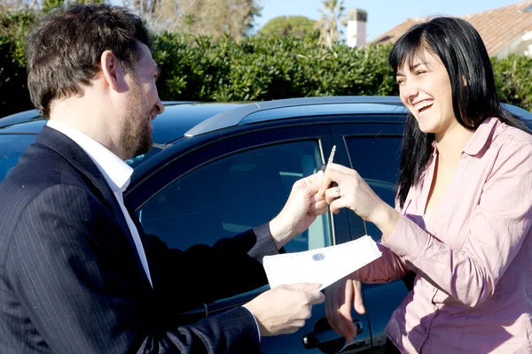 Usměvavý obchodník dát ženě dokumenty a klíče od nového vozu — Stock fotografie