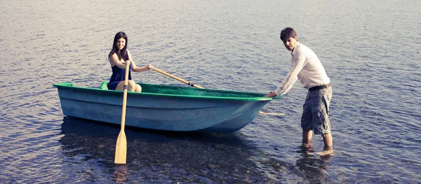 Couple in vacation with boat on lake — Stock Photo, Image