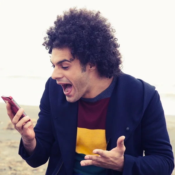 Knappe man verrast door tekstbericht op de telefoon — Stockfoto