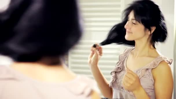Mujer mirando al espejo y peinando el cabello — Vídeos de Stock