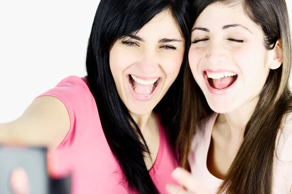 Primo piano di ragazze che ridono scattando foto con smart phone — Foto Stock
