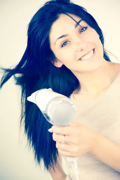 Mulher sorridente com secador de cabelo — Fotografia de Stock