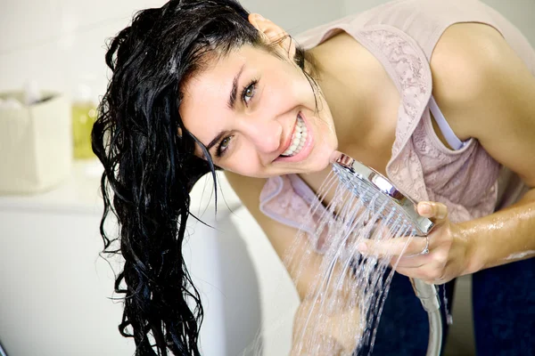 Jonge vrouw wassen lange haren — Stockfoto