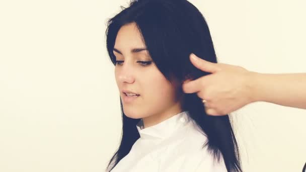 Парикмахер выпрямляет женские волосы — стоковое видео