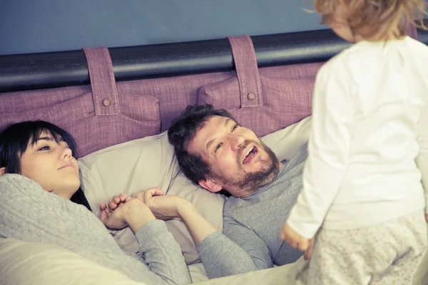 Meisje, moeder en vader in bed wakker — Stockfoto