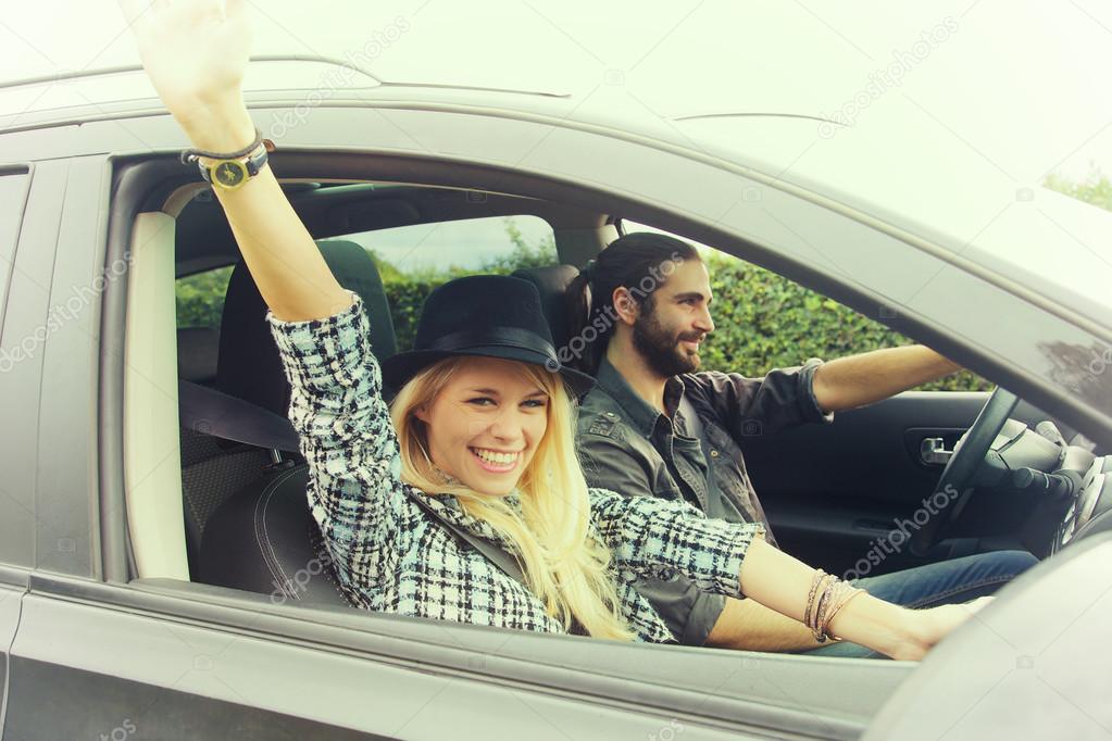 happy young couple driving on the road