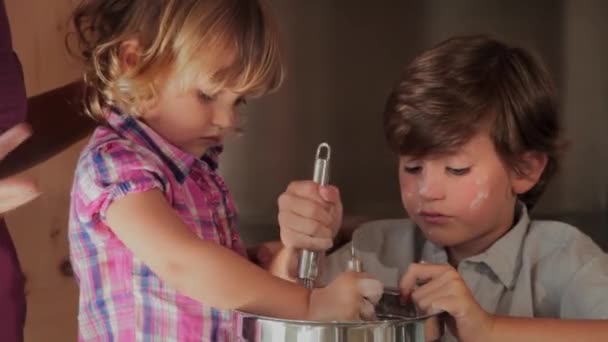 Çocuklar evde annesi tarafından yardımcı bir pasta pişirme — Stok video
