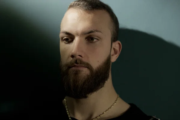 Handsome pensive man in darkness with ray of light — Stock Photo, Image