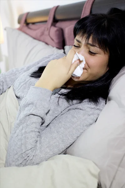 Mujer enferma estornudando nariz en la cama enferma infeliz — Foto de Stock