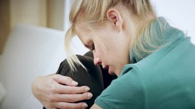 Duygu üzgün ve yalnız kanepe portre üzerinde oturan sarışın bir kadın