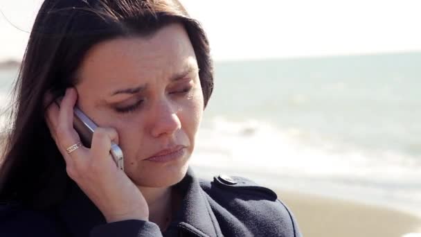 Smutný byznys žena pláče na pláži na detailním telefon — Stock video