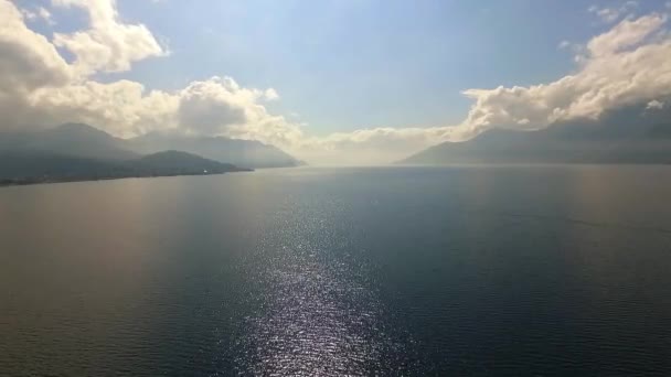 Повітряний знімок озера з хмарами і горами — стокове відео