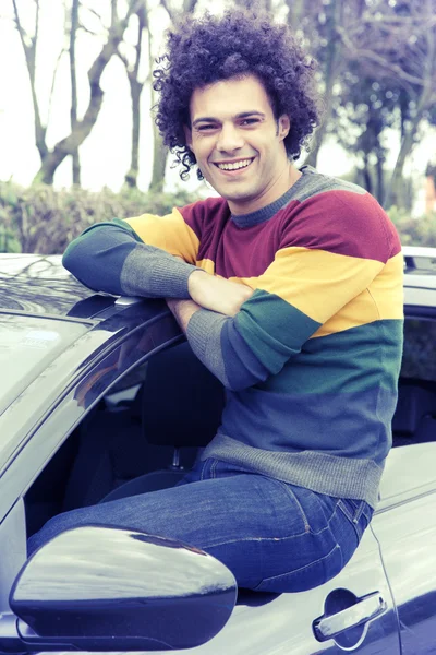 Cool hombre sonriendo mirando cámara sentado en la ventana del coche aspecto vintage —  Fotos de Stock