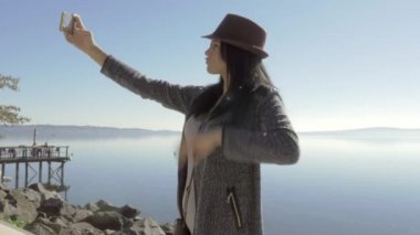 Göl ile şapka mutlu önünde selfie alarak şirin genç kadın