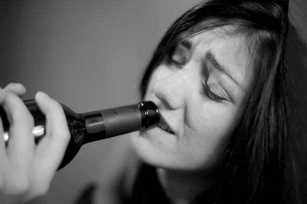 Drunk woman drinking wine crying black and white — Stock Photo, Image